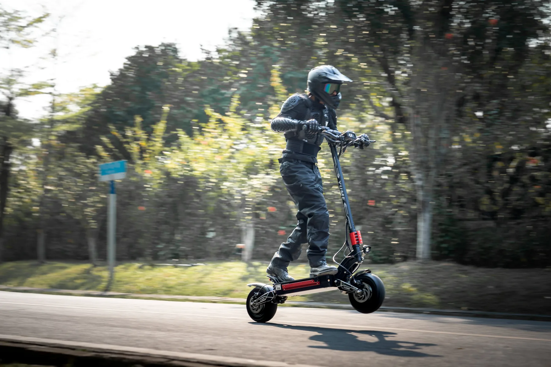 YUME Raptor 2 electric scooter at speed on a sealed road, background blurred